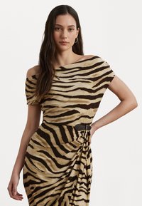Mekko, jossa on epäsymmetrinen olka, beige kangas mustilla tiikeriraitapainatuksilla, kerätty vyötärö ja ruskea vyöyksityiskohta. Sileä pinta.