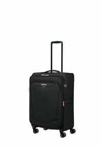 Black soft-shell suitcase with four wheels, telescopic handle, and front zipper pocket; features orange accents and smooth texture.