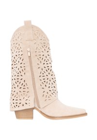 Beige suède middenkuitlaars met geometrische uitgesneden patronen, zijrits, treklipje, spits toelopende neus en gestapelde lage hak.