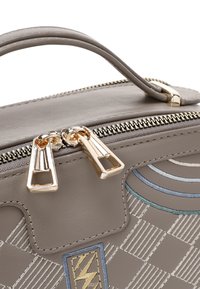 Grijze lederen handtas met gouden hardware, voorzien van een ritssluiting, geometrisch patroon en gestikte accenten in blauw en goud.