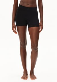 Shorts de sport noirs fabriqués en tissu doux et extensible. Taille haute, longueur mi-cuisse, et design sans coutures avec des détails de couture minimaux.