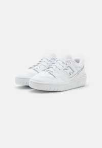 Baskets blanches en cuir avec une texture lisse, présentant un bout rond, des lacets et une semelle en caoutchouc avec une adhérence texturée.
