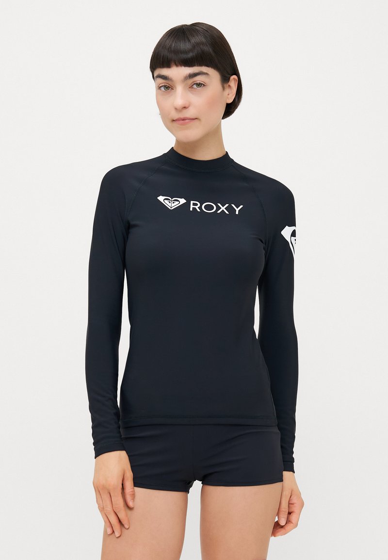 Fekete, hosszú ujjú úszó póló rugalmas anyagból, magas nyakkal, fehér "ROXY" logóval és oldalsó emblémával.