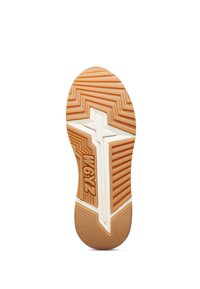 Suola di una sneaker con un pattern a zigzag in gomma beige, con un dettaglio bianco e logo impresso, piatta e arrotondata nel tallone.