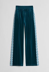 Tyrkysové sametové kalhoty s širokými nohavicemi a elastickým pasem, s bočními kapsami a kontrastními bílými bočními pruhy s řetízkovým vzorem.
