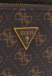 Matériau synthétique marron à motifs avec un logo dans un triangle doré. Le design comprend des formes entrelacées et des lignes diagonales.