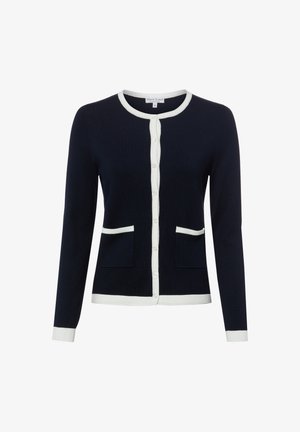 Cardigan bleu marine avec bord blanc sur le col, la patte de boutonnage, les poignets, l'ourlet et les bords des poches, avec manches longues et boutons sur le devant.