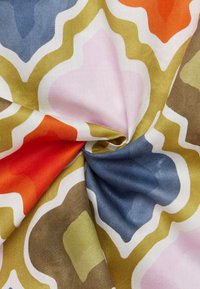 Mønstret stof med buede former i orange, pink, blå og grøn. Glat tekstur med en satinlignende finish. Abstrakt design.