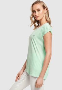 Merchcode LOVE YOURSELF FIRST EXTENDED SHOULDER - T-shirts med print - neo mint