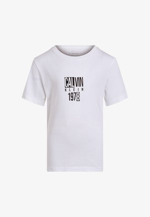 Hvid T-shirt med korte ærmer med sort tekst "CALVIN KLEIN 1978" trykt i blokbogstaver midt på forsiden.
