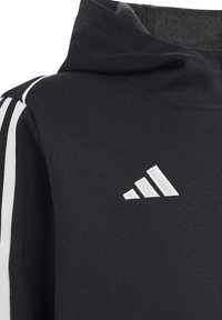 Schwarzer Hoodie mit einer weichen Textur, der weiße Streifenakzente an den Ärmeln und ein weißes gesticktes Logo auf der Brust aufweist.
