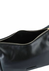 Borsa a tracolla in pelle nera con cerniera dorata, caratterizzata da una texture liscia e un design minimalista. Vista aperta che mostra la fodera interna.