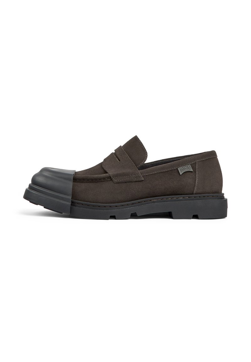 Tmavě hnědé semišové slip-on boty s gumovou špičkou, nízkým profilem, šitými detaily a robustní černou gumovou podrážkou.