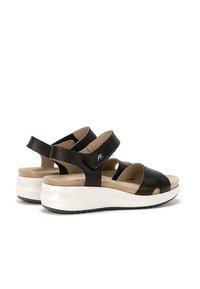 Sandalias de cuero negras con correas ajustables, diseño de punta abierta, plantilla acolchada y suela de plataforma blanca ligera para mayor comodidad.