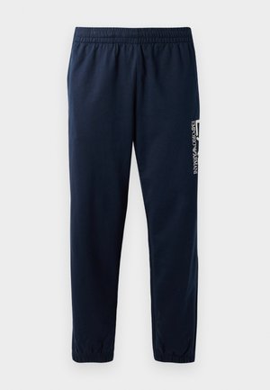 Pantalones de chándal azul marino con cintura elástica, piernas ajustadas y un logo blanco en el lateral. Tejido suave con una textura ligera.