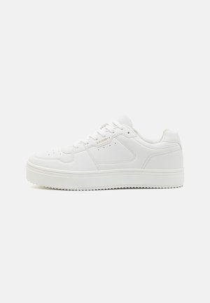 White leather sneakers with a low-top design, rounded toe, and textured sole. Features perforated detailing and minimalistic stitching accents.
