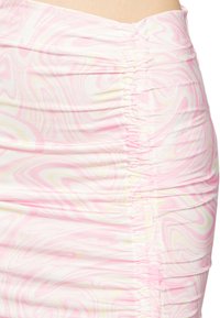 Saias mini de cetim com um padrão espiral em rosa, branco e amarelo. Apresenta detalhes franzidos na lateral para textura e forma.