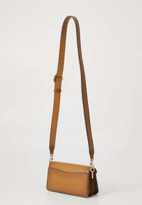 Brown leather crossbody bag with a smooth texture, rectangular shape, and adjustable strap. Features gold-tone hardware and a subtle seam detail.