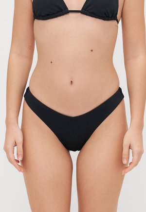 Culotte bikini nera con texture rigata, taglio a vita bassa e cuciture laterali. Il tessuto è liscio con una leggera lucentezza, progettato per l'uso in costume da bagno.