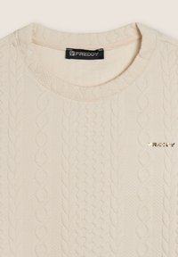 Maglione in crema con texture, caratterizzato da un motivo a trecce, scollatura rotonda e un logo metallico dorato "FREDDY" sul davanti.