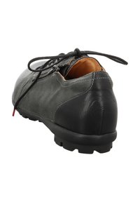 Dunkelgrauer Wildlederschuh mit einem hinteren Abschnitt aus Leder, schwarzer Gummisohle mit Profil und kontrastierendem tannfarbigen Innenfutter mit Schnürsenkeln.