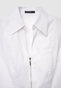 White collared shirt featuring a central zip closure, made from smooth fabric with a clean, structured silhouette. Size tag reads "S."