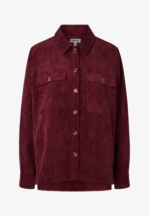 Mély bordó színű kordgalléros ing hosszú ujjakkal, két mellkasi zsebfedéllel és barna gombokkal elöl.