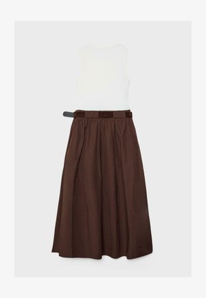 Hvid ærmeløs top kombineret med en brun plisseret midi-nederdel med højtaljet design, bred taljesøm og bæltestropper.