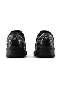 Adidași atletici negri cu un superior din plasă, accente reflective și o talpă din cauciuc rezistent. Au un guler căptușit și detalii cu logo pe călcâi.