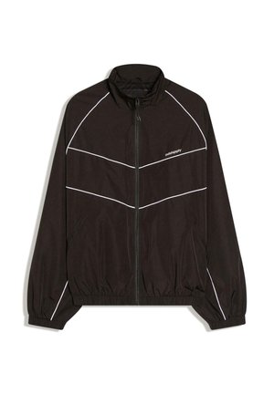 Czarna kurtka wiatrówka z zamkiem z przodu, wysokim kołnierzem i elastycznymi mankietami. Posiada białe ukośne paski i logo na piersi.