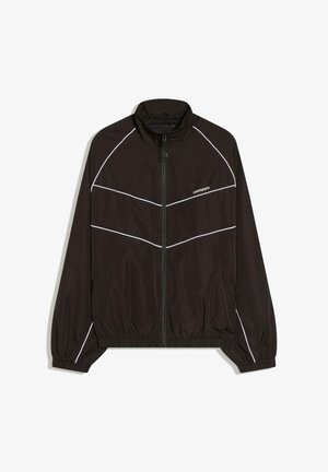 Czarna kurtka wiatrówka z zamkiem z przodu, wysokim kołnierzem i elastycznymi mankietami. Posiada białe ukośne paski i logo na piersi.