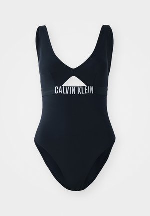 Must must ühik, millel on V-kaelus, lõike detail ja bränditud elastne riba, millel on valged tähed "CALVIN KLEIN".