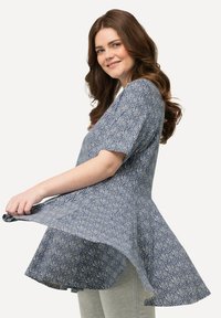 Top blu con motivo, maniche corte, orlo svasato, realizzato in tessuto leggero, presenta disegni intricati e una vestibilità comoda.