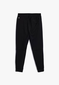 Zwarte sportieve joggers met een elastische tailleband, taps toelopende benen en ribgebreide boorden. Gemaakt van een soepele, rekbare stof met minimale details.