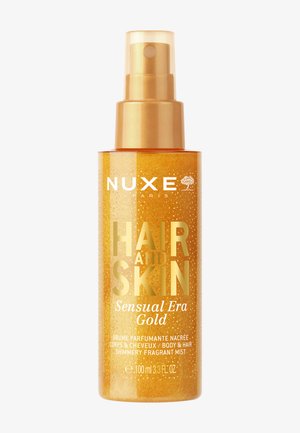 Nuxe Paris Hair and Skin Sensual Era Gold spray de niebla perfumada y brillante para cuerpo y cabello en un frasco dorado de 100 ml.