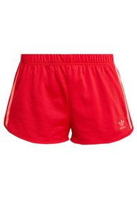 Červené sportovní šortky Adidas s elastickým pasem, světle růžovými bočními pruhy a logem Adidas na dolní části levé nohavice.