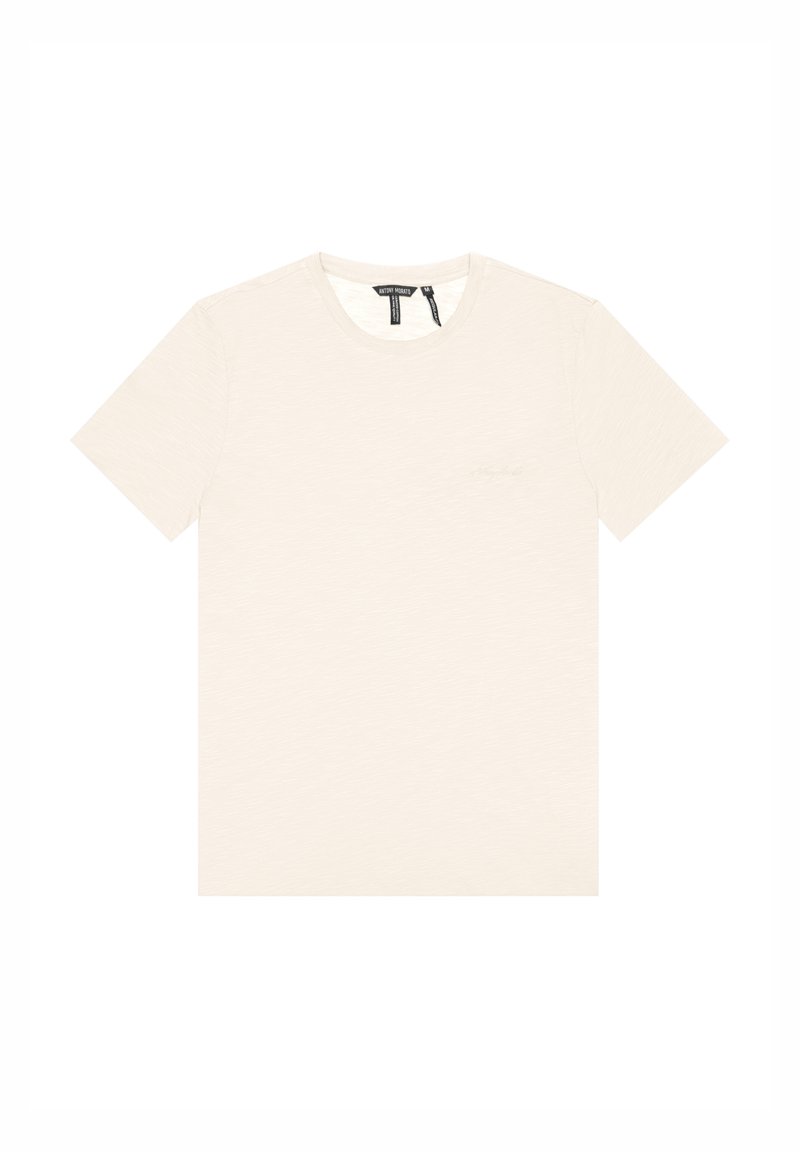 T-shirt beige chiaro realizzata in tessuto testurizzato, con scollo rotondo e maniche corte. Piccolo logo in evidenza sul davanti.