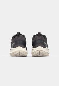 Black athletic shoes with a textured upper, contrasting grey accents, and a sturdy outsole featuring a lug pattern for traction.