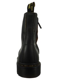 Svarta läderankelboots med en gul och svart dragflik, en sidodragkedja och kontrasterande bruna accenter. Tjock, strukturerad sula.