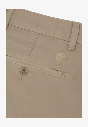 Tessuto beige con una tasca a filetto con bottone, passante per cintura e logo ad albero ricamato su un paio di pantaloni.