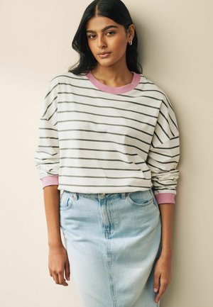 Vit och grå randig sweatshirt med rosa ribbad krage och muddar, ihop med en ljusblå jeankjol. Mjuk tygkvalitet och avslappnad passform.