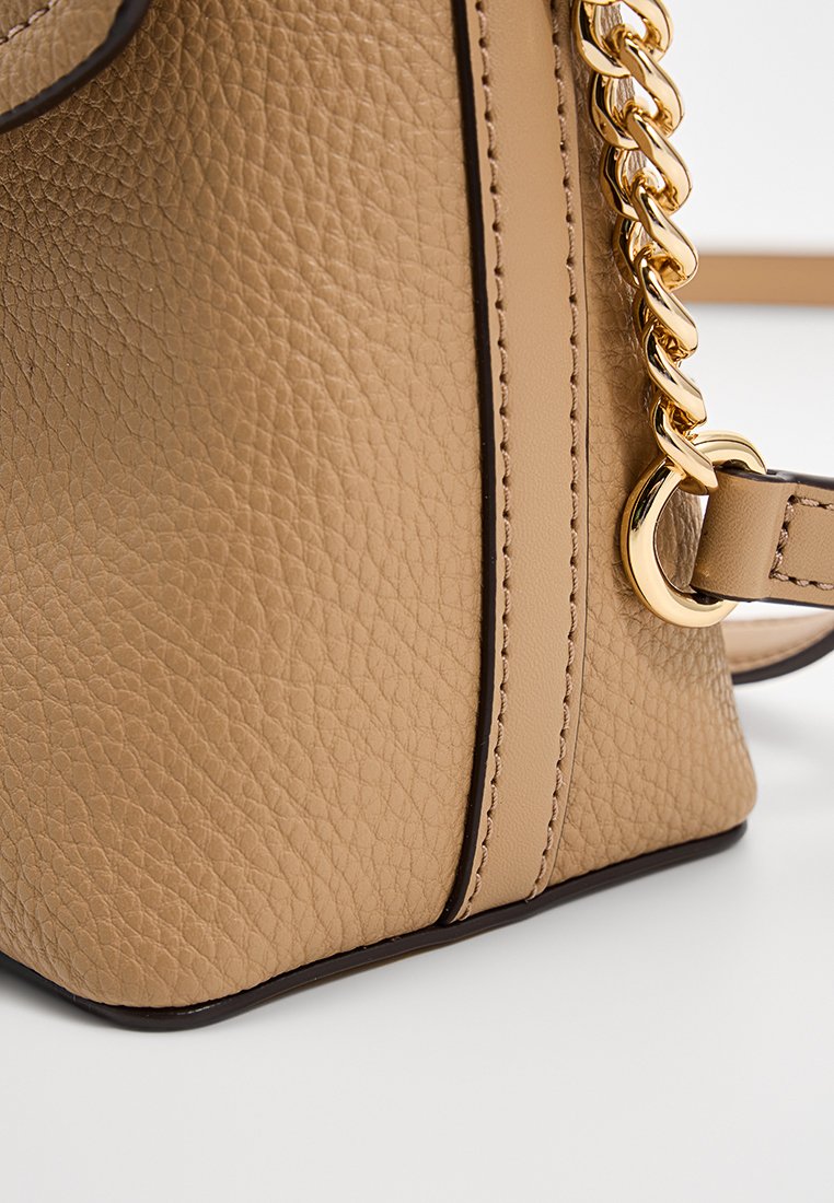 Tan leren handtas met een gestructureerd oppervlak, voorzien van een kettingband in goudkleur en een contrasterende donkere rand. Compac rectangular formaat.