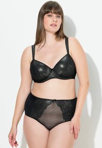 Set di intimo nero composto da un reggiseno imbottito con dettagli in pizzo e slip a vita alta con un pannello trasparente. Texture morbida e lucida, design elegante.