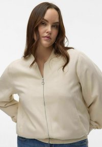 Beige bomber jacket with a front zipper, ribbed cuffs, and pockets. Made from a smooth fabric, featuring a relaxed fit and minimal design.