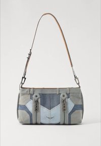 Sac à bandoulière en jean avec des panneaux bleu clair et bleu foncé, doté de deux fermetures éclair à l'avant et d'une bandoulière réglable en cuir marron.
