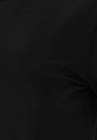 Black fabric top featuring a smooth texture and fitted design, without visible seams or embellishments.