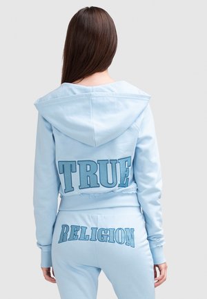 Lichtblauwe hoodie met grote geborduurde "TRUE" op de achterkant. Gelaagd stof en cropped ontwerp. Bijpassende joggers met accent "RELIGION".