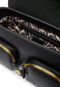 Borsa in pelle nera con texture, dotata di due tasche anteriori con zip e foderata in tessuto con stampa leopardata all'interno del compartimento principale.