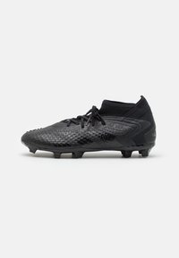Schwarze Fußballschuhe mit strukturiertem Synthetik-Obermaterial, niedrigem Design, Schnürverschluss und geformten Stollen für Griffigkeit auf Rasenflächen.