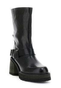 Černá kožená kotníková bota s masivním zeleným podpatkem a platformou, zdobená černým páskem se stříbrnou sponou. Hladký povrch.